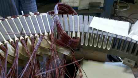 Laying the magnet wire into the fishpaper-lined stator core slots